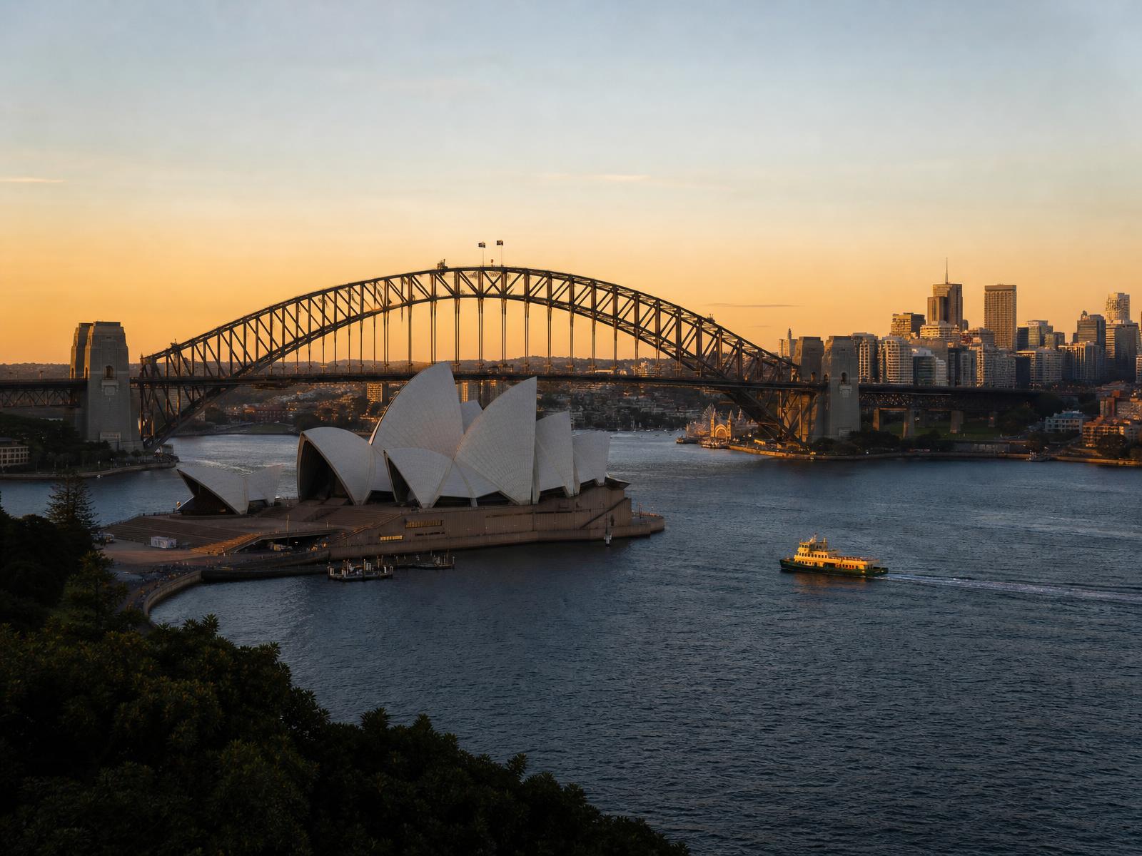 Sydney Opera House and Harbour Bridge at sunset across Sydney Harbour in Australia